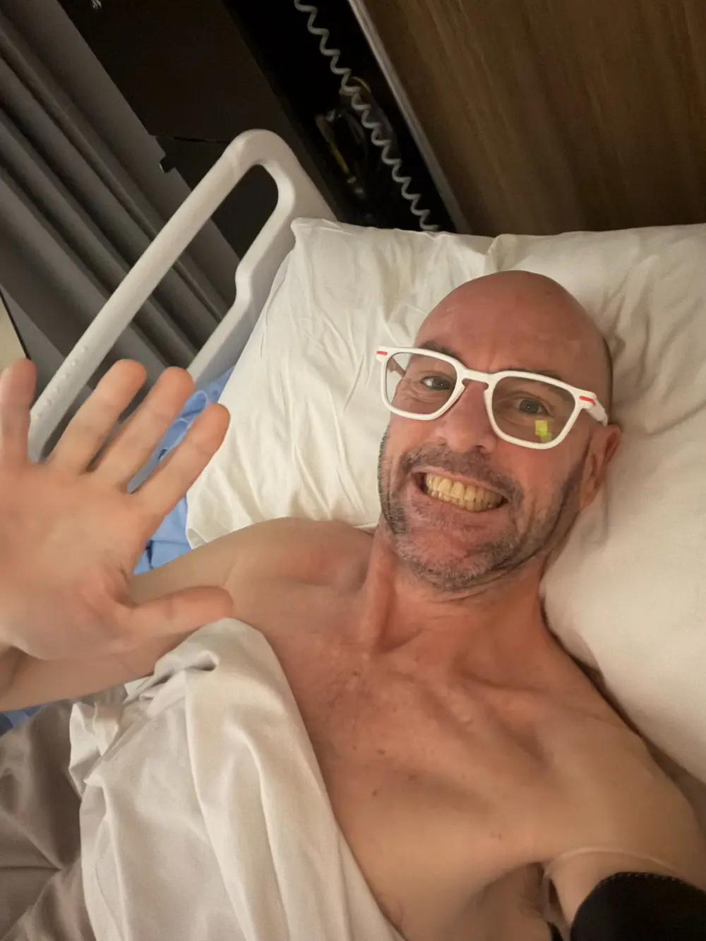 Adam waving from his hospital bed on Friday morning